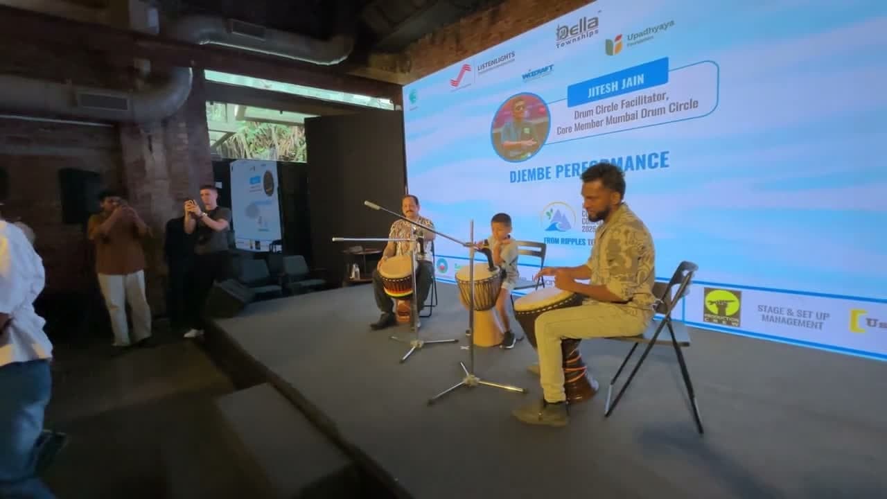 Jitesh Jain leading a djembe drum circle performance with the audience on stage at ICUC 2.0